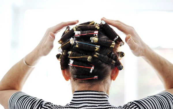 Mulher com encrespadores no cabelo, costas — Fotografia de Stock
