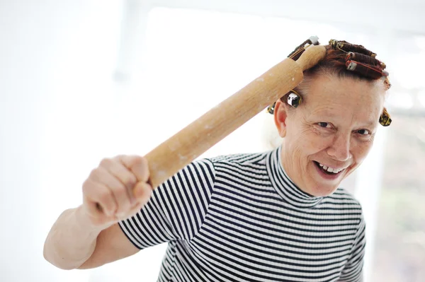 Seniorin mit Nudelholz und Lockenwickler im Haar — Stockfoto