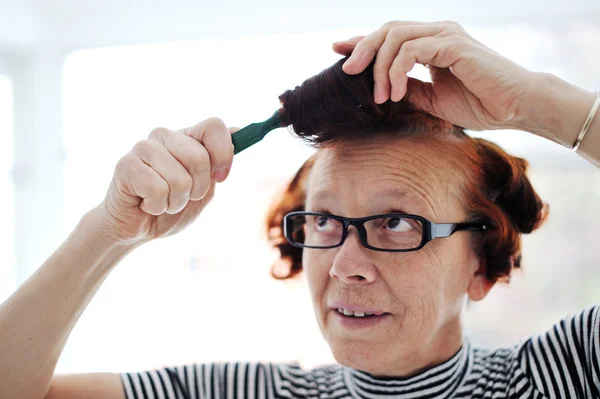 Sénior pente de cabelo senhora — Fotografia de Stock