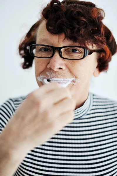 Пожилая женщина чистит зубы — стоковое фото