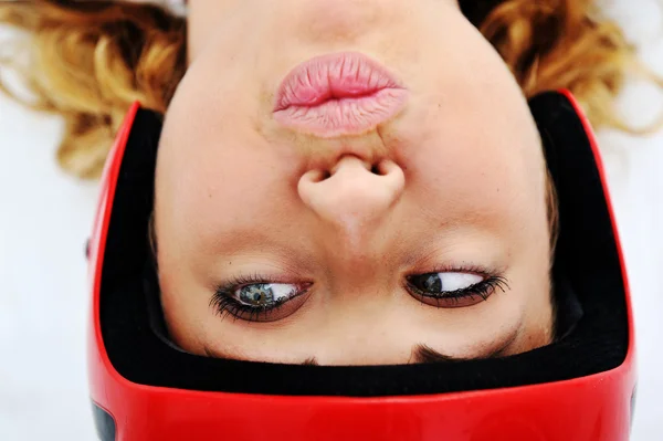 Menina engraçada com capacete vermelho e expressão boba — Fotografia de Stock
