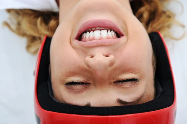 Menina engraçada com capacete vermelho sorrindo — Fotografia de Stock