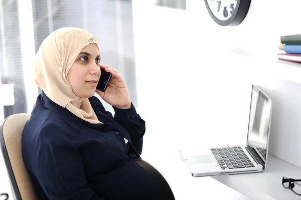 Беременная арабская арабская деловая женщина разговаривает по телефону — стоковое фото