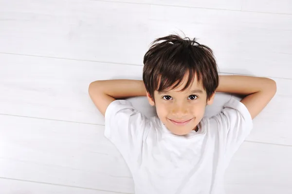 Mały chłopiec r. złagodzone na białej podłogi w domu — Zdjęcie stockowe