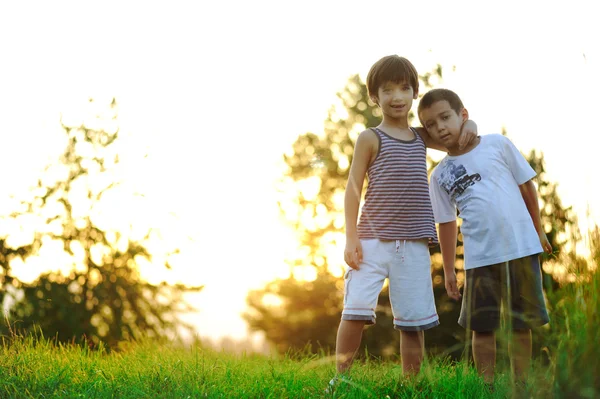 Boldog gyermekek, a természetben, a naplemente — Stock Fotó