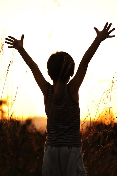 Šťastné dítě těší v přírodě při západu slunce — Stock fotografie