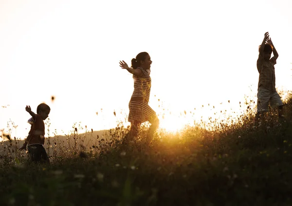 Crianças felizes na natureza ao pôr do sol — Fotografia de Stock