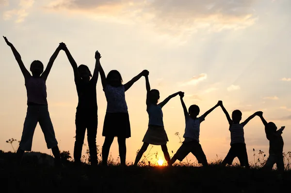 Várias gerações de crianças com braços para cima na natureza — Fotografia de Stock