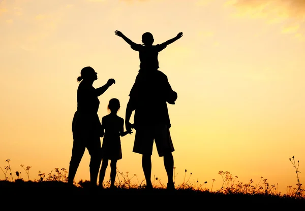 Šťastná rodina v přírodě při západu slunce — Stock fotografie