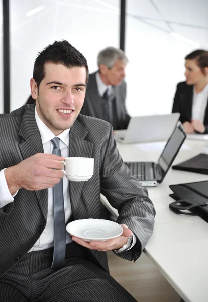 Επιχειρηματία στο επιχειρηματικό περιβάλλον πίνοντας καφέ — Φωτογραφία Αρχείου