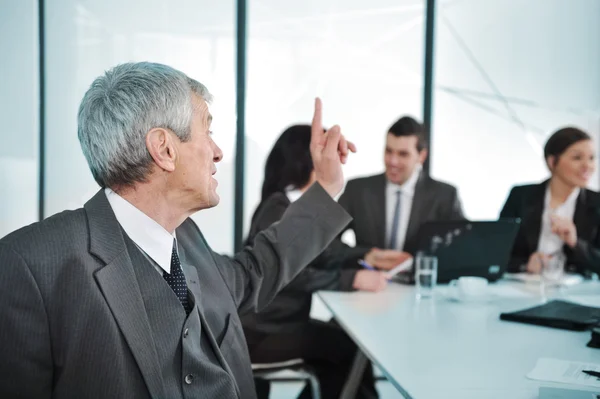 Senior zakenman tijdens een vergadering. groep collega's op de achtergrond — Stockfoto