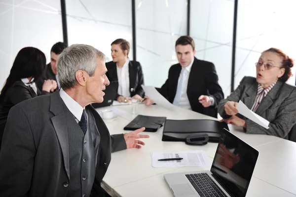 Senior affärsman vid ett möte. grupp av kollegor i bakgrunden — Stockfoto