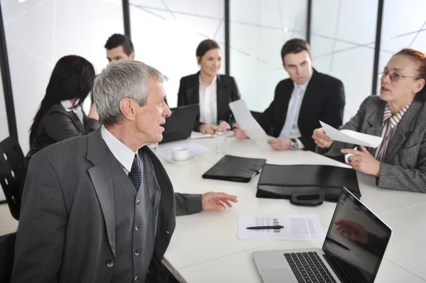 Senior affärsman vid ett möte. grupp av kollegor i bakgrunden — Stockfoto