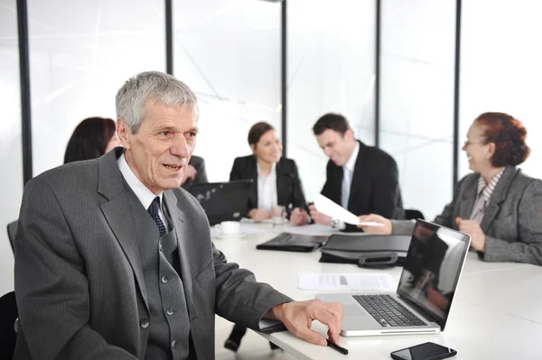 Senior zakenman tijdens een vergadering. groep collega's op de achtergrond — Stockfoto