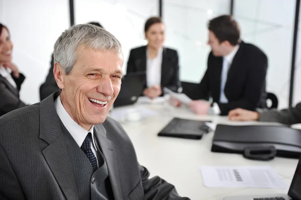 Senior Geschäftsmann bei einem Treffen lachend — Stockfoto