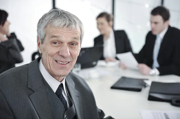 Senior zakenman tijdens een vergadering. groep collega's op de achtergrond — Stockfoto