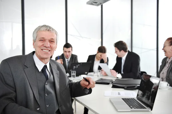Senior zakenman tijdens een vergadering. groep collega's op de achtergrond — Stockfoto