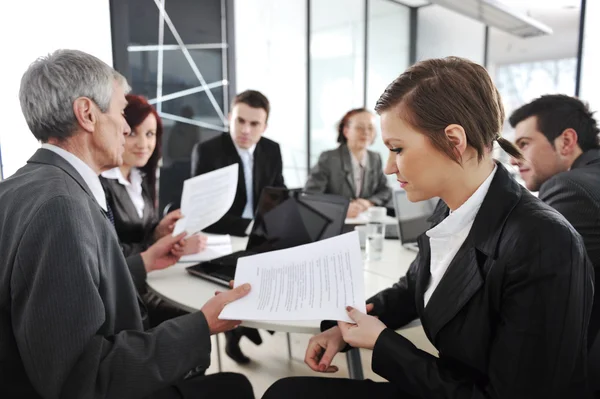 Young businesswoman in business meeting at office with colleagues in background — Stock Photo, Image