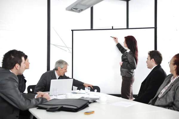 Geschäftsfrau zeichnet während der Präsentation im Büro eine Grafik auf Whiteboard — Stockfoto