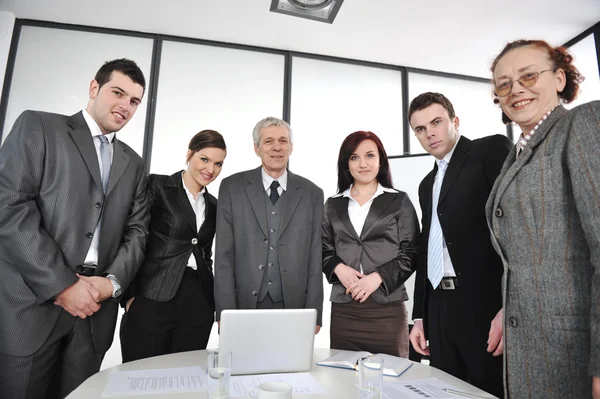 Multi aged business standing around the table at office — Stock Photo, Image