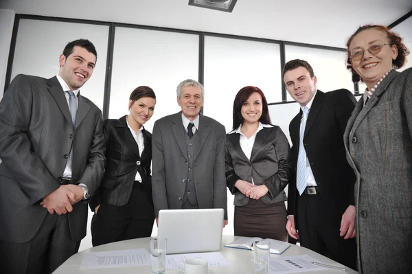 Negócios multi envelhecidos em pé em torno da mesa no escritório — Fotografia de Stock