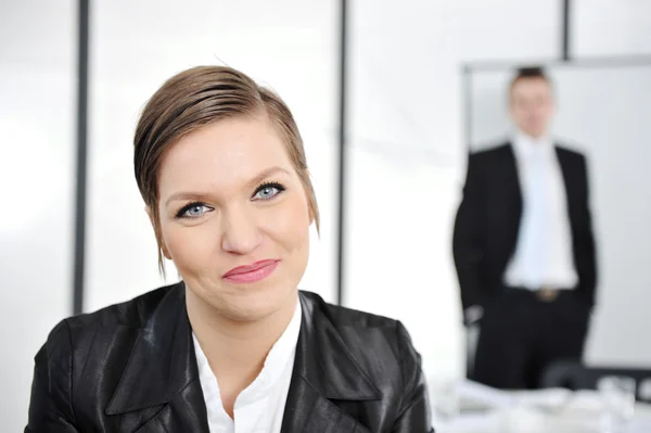Joven mujer de negocios en reunión de negocios en la oficina, mirando a la cámara sonriendo — Foto de Stock