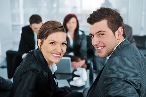 Zakenman en zakenvrouw kijken camera op office meetin — Stockfoto