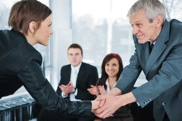 Jonge zakenvrouw doorgegeven op een sollicitatiegesprek schudden handen met baas — Stockfoto