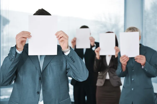 Équipe d'affaires de quatre personnes tenant du papier blanc — Photo