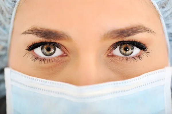 Médica mulher vestindo tampa cirúrgica e máscara — Fotografia de Stock