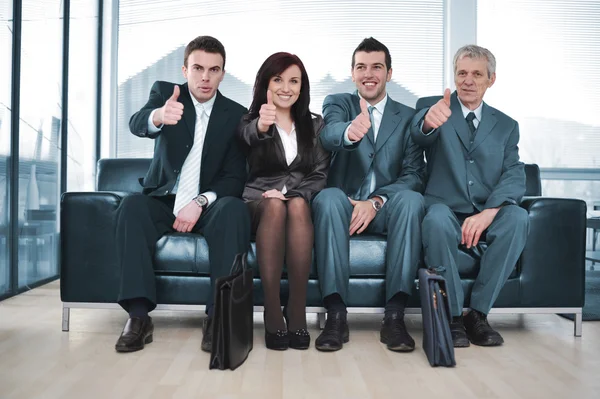 Группа бизнеса, сидящая на диване с большими пальцами вверх — стоковое фото