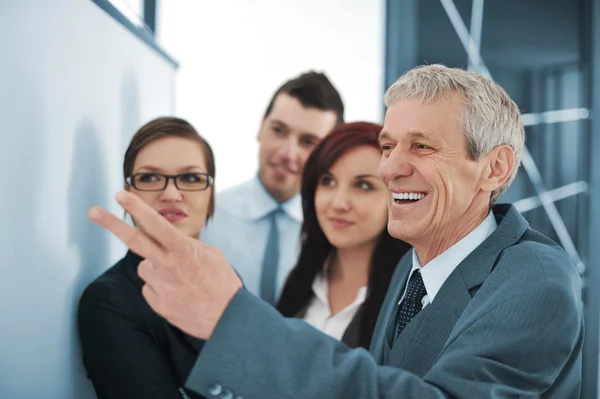 Boss explaining graph to his team — Stock Photo, Image