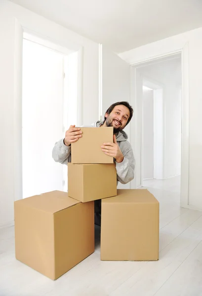 Hombre con cajas moviéndose en casa nueva —  Fotos de Stock