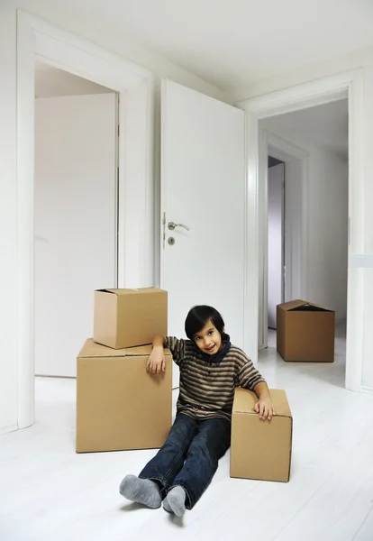 Menino com caixas móveis na nova casa — Fotografia de Stock