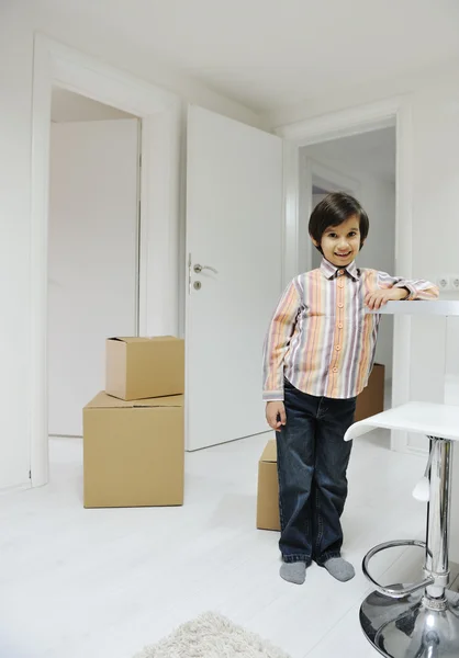 Little boy with moving boxes at new home — Stock Photo, Image