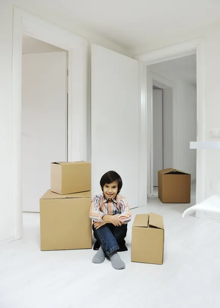 Petit garçon avec des boîtes de déménagement à la nouvelle maison — Photo