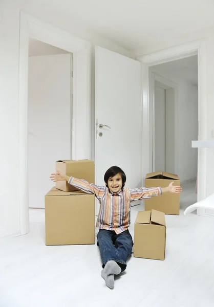 Little boy with moving boxes at new home — Stock Photo, Image