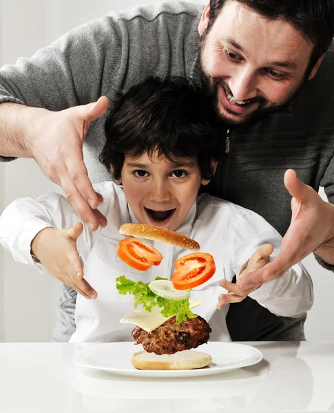Criança e pai fazendo hambúrguer juntos — Fotografia de Stock