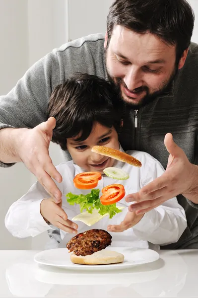 Levitando hambúrguer no ar feito por pai e filho — Fotografia de Stock