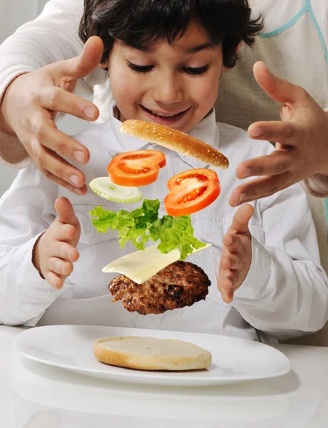 Anne ve burger elinde olan küçük çocuk — Stok fotoğraf