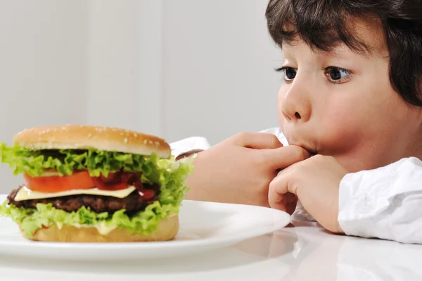 Malý chlapec a burger — Stock fotografie