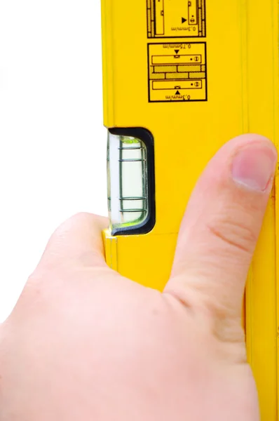 Ręka trzyma żółty poziomu narzędzie — Zdjęcie stockowe