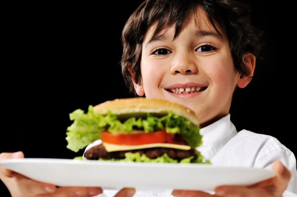 Маленький хлопчик пропонує гамбургер на тарілці — стокове фото