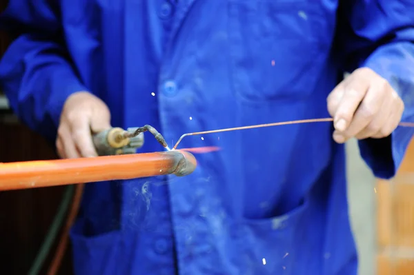 Arbeiter im blauen Anzug schweißt Metall — Stockfoto
