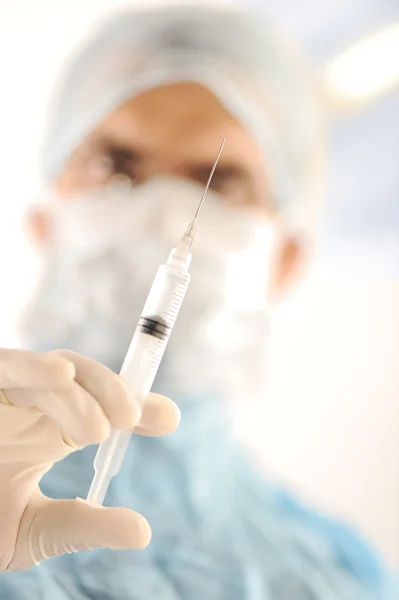 Médico cirurgião segurando uma injeção na sala de cirurgia — Fotografia de Stock