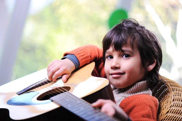 Enfant jouant de la guitare à la maison Image En Vente