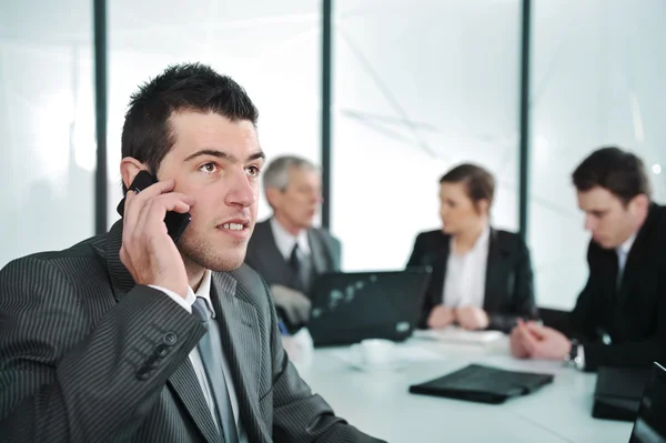 Деловой человек разговаривает по телефону во время встречи Стоковое Фото