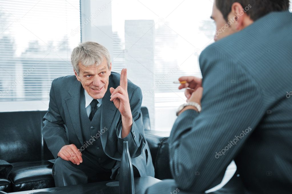 Business talking while boss is finger pointing