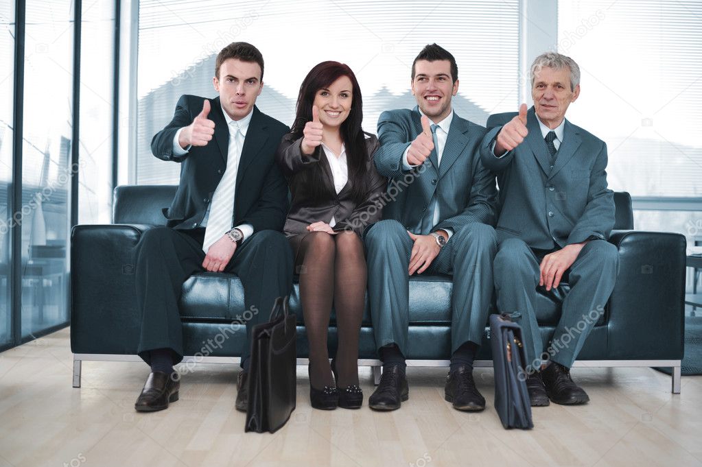 Group of business sitting on sofa with thumbs up