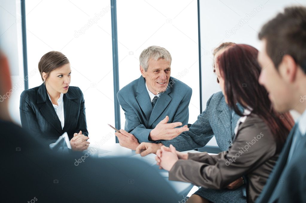 Portrait of a positive manager with his team sitting at the table